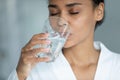 Thirsty young african american woman drinking glass of water. Royalty Free Stock Photo