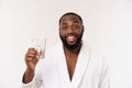 Thirsty young african man holding glass drinking water for body health isolated on white studio background Royalty Free Stock Photo