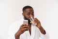 Thirsty young african man holding glass drinking water for body health isolated on white studio background Royalty Free Stock Photo