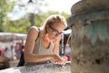 Thirsty young casual cucasian woman wearing medical face mask drinking water from public city fountain on a hot summer Royalty Free Stock Photo