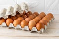 Thirty brown chicken eggs in a cardboard tray packaging on a white wooden table. Raw fresh hen eggs in a carton box. Ingredient Royalty Free Stock Photo