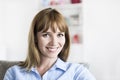 Thirty-year-old natural woman seated in modern home. Looking camera Royalty Free Stock Photo