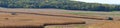 Panorama landscape of a John Deer combine harvesting a corn field