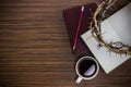 Thorn crown with notebook, Bible, and coffee on a wooden table. Royalty Free Stock Photo