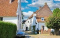 Idyllic courtyard of traditional white dutch country houses with classic car in rural village