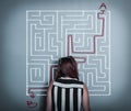 Thoughful woman is considering how to shorten the path through the maze Royalty Free Stock Photo