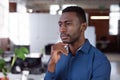 Thoughtful african american businessman standing in office looking away Royalty Free Stock Photo