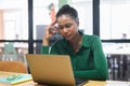 Thoughtful african american female office employee using laptop indoors Royalty Free Stock Photo