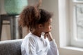 Thoughtful African American preschooler girl looking in window