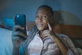 Thoughtful Afro American millennial woman as social media addict - night lifestyle portrait of young beautiful and cool girl Royalty Free Stock Photo