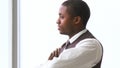 Thoughtful AfroAmerican businessman with folded arms in office