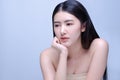 Thoughtful amature beauty. Side view of thoughtful amature asian woman holding hand on chin and looking away while standing Royalty Free Stock Photo