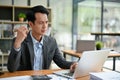 A thoughtful Asian businessman focuses on his tasks on his laptop, working at his desk Royalty Free Stock Photo