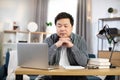 Thoughtful asian man looking at computer screen Royalty Free Stock Photo