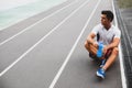 Thoughtful athlete drinking bottle of water outdoor