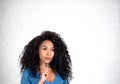 Thoughtful attractive African American businesswoman is standing touching chin Royalty Free Stock Photo