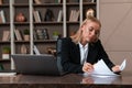 Thoughtful attractive businesswoman wearing formal wear sitting reading contract