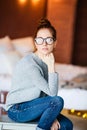 Thoughtful attractive redhead woman bending forwards and looking up to the side with a contemplative expression against Royalty Free Stock Photo