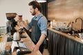 barista appraisingly looks at a glass of filter coffee