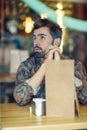 Thoughtful bearded man wearing casual clothes sitting in a moder Royalty Free Stock Photo