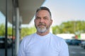 Thoughtful bearded senior man standing in an outdoor carpark Royalty Free Stock Photo