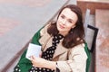 Thoughtful beautiful girl with book in city park. Beautiful young woman looking at the camera.  Copy space Royalty Free Stock Photo