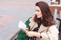 Thoughtful beautiful girl reading book in city park. Beautiful young woman on the street of the city. Copy space Royalty Free Stock Photo