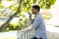 Thoughtful biracial man drinking coffee and standing on balcony at home, copy space