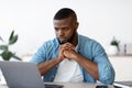 Thoughtful Black Freelancer Guy Sitting At Desk And Looking At Laptop Screen Royalty Free Stock Photo