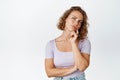 Thoughtful blond girl consider something interesting, looking up and thinking, standing against white background