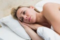 Thoughtful blonde lying in bed Royalty Free Stock Photo