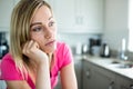 Thoughtful blonde woman leaning on her counter Royalty Free Stock Photo