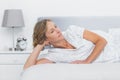 Thoughtful blonde woman lying on bed Royalty Free Stock Photo