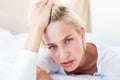 Thoughtful blonde woman lying on the bed Royalty Free Stock Photo