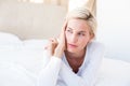 Thoughtful blonde woman lying on the bed Royalty Free Stock Photo