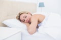 Thoughtful blonde woman lying in bed Royalty Free Stock Photo