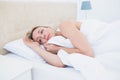 Thoughtful blonde woman lying in bed Royalty Free Stock Photo
