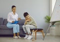 Thoughtful boy during meeting with professional psychotherapist in white room with blue sofa. Royalty Free Stock Photo