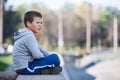 Thoughtful boy sitting on edge of granite plate, looks into the distance Royalty Free Stock Photo