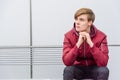 Thoughtful boy sitting outdoor on bench portrait over urban back