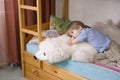 Thoughtful Boy With Soft Toy Lying On Bunk Bed