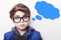 Thoughtful young boy wearing glasses with an empty thought bubble Royalty Free Stock Photo