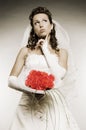 Thoughtful bride with bunch of flowers