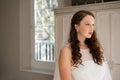 Thoughtful bride looking away while standing at home