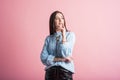 Thoughtful brunette girl in studio on pink background. Royalty Free Stock Photo