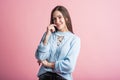 Thoughtful brunette girl in studio on pink background. Royalty Free Stock Photo