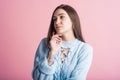 Thoughtful brunette girl in studio on pink background. Royalty Free Stock Photo