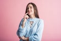 Thoughtful brunette girl in studio on pink background. Royalty Free Stock Photo