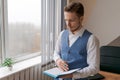 Thoughtful business man with beard in shirt and vest with notepad in his hand Royalty Free Stock Photo