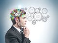 Thoughtful businessman and cog brain with gears Royalty Free Stock Photo